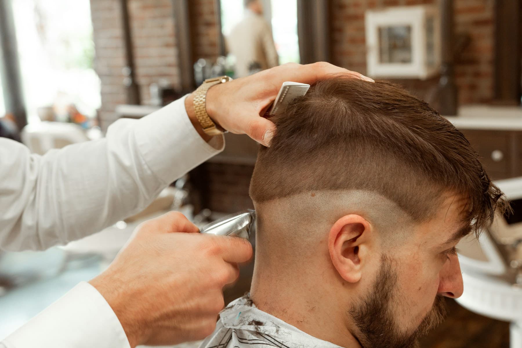 Barber trimming a seated man's hair