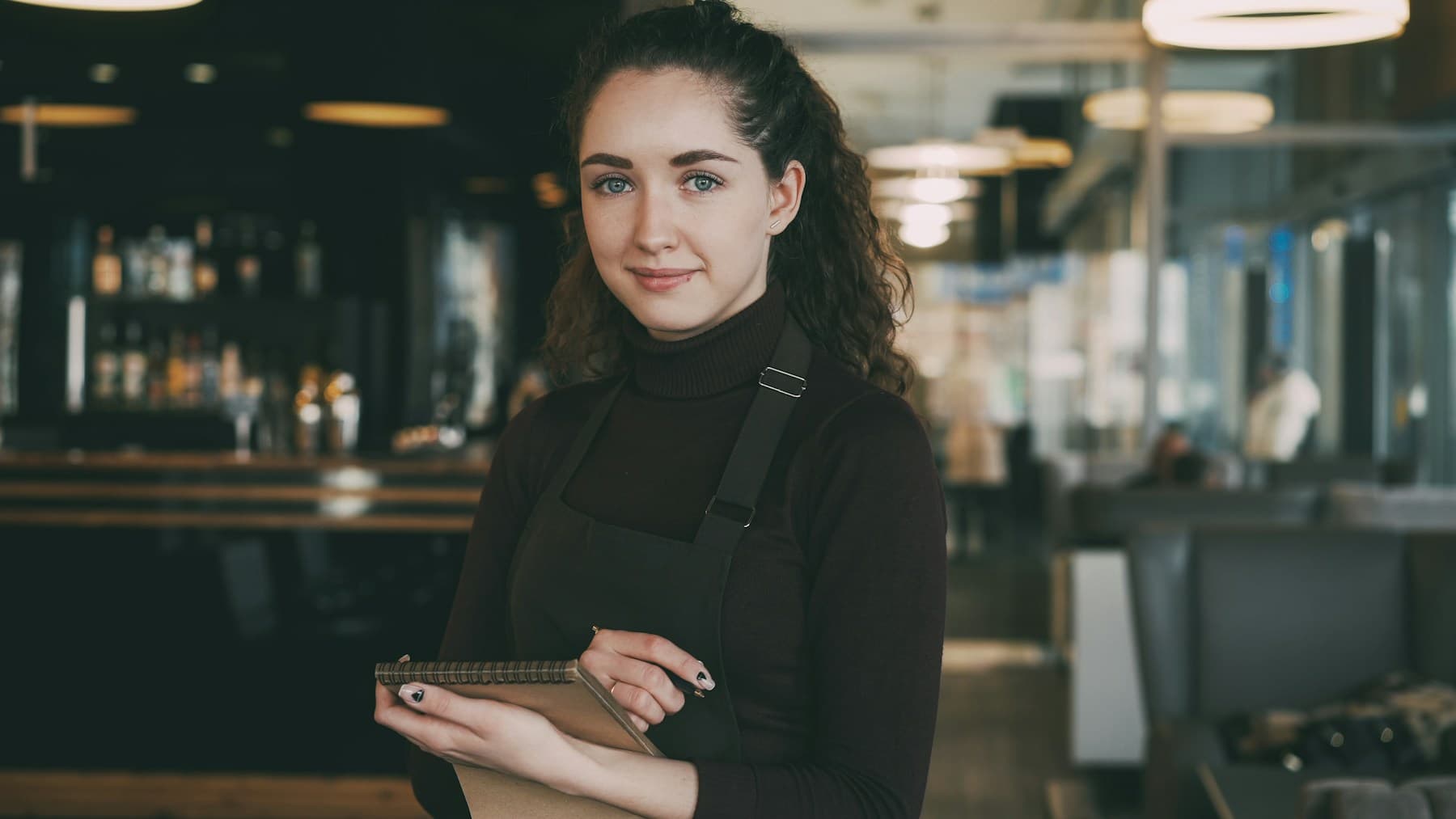 Restaurant server holding an order pad during service
