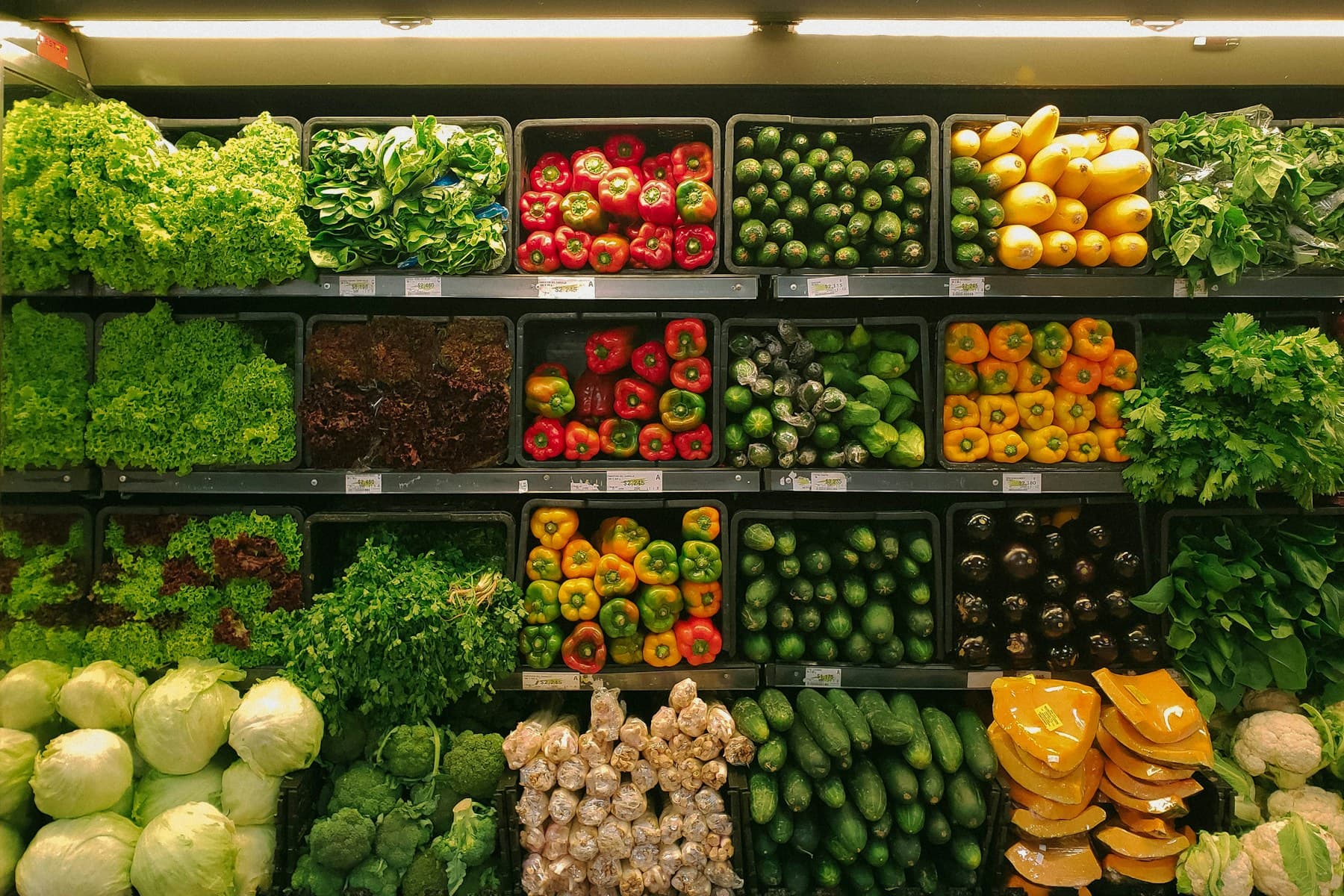 Fresh produce arranged on refrigerated retail store shelves
